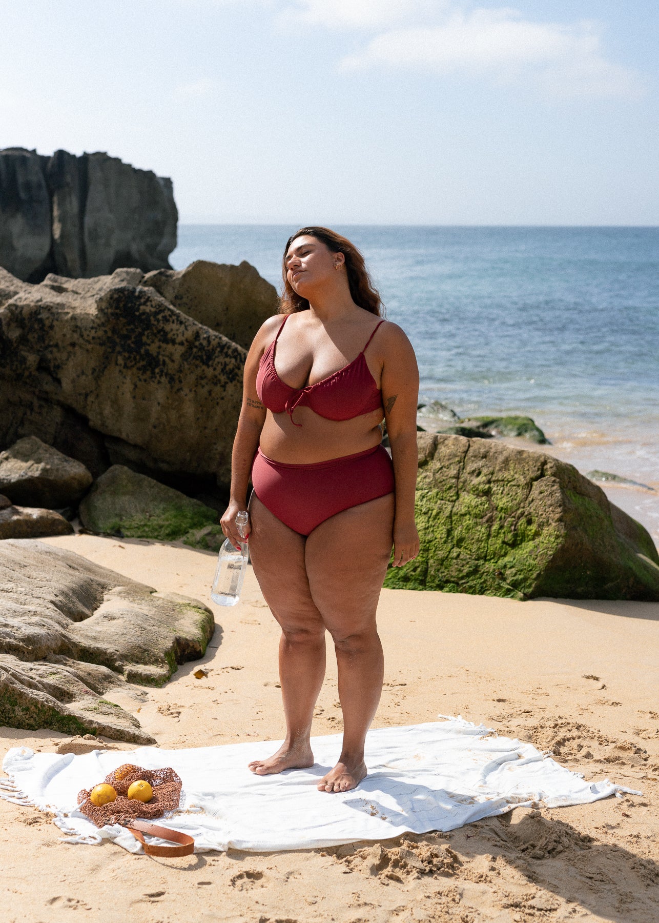 Red-brown bikini top with drawstring by Lilja the Label, seen worn with matching bottoms at the beach.