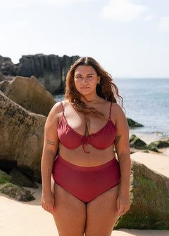 Burgundy drawstring top by Lilja the Label worn with matching bottoms on a beach setting.